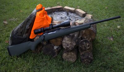 glenfield model a rifle with an orange hunting vest and backpack