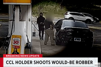 Surveillance image showing a masked person approaching a customer beside an Acura at an Orland Park gas pump.