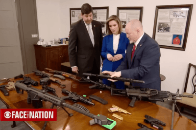 Firearms displayed on a table during a CBS Face the Nation segment about gun policy.