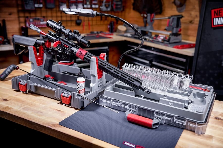 Rifle secured inside the Real Avid Bore-Max Master Cleaning Kit with brushes, lighting and maintenance tools arranged nearby.