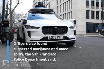 White Jaguar equipped with autonomous-driving sensors on a city street, shown in Colion Noir’s video.